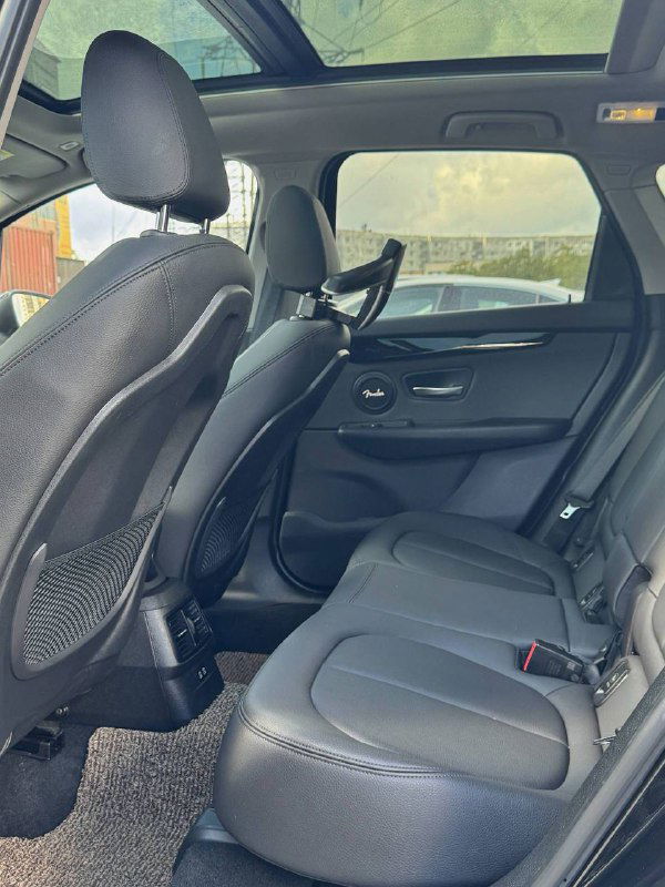 Вид второго ряда сидений BMW 2-Series Active Tourer с панорамной крышей и обзором пространства для пассажиров и места для ног.