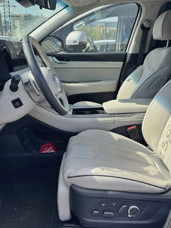 Передние светлые кожаные сиденья Hyundai Palisade в комплектации Calligraphy, вид сбоку с видимыми регулировками и центральной консолью между креслами.