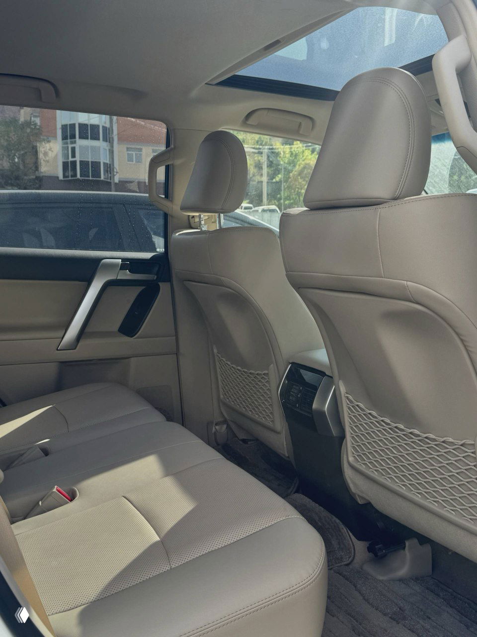 Вид задних сидений и пространства для пассажиров Toyota Land Cruiser Prado 2021: кресла в хорошем состоянии, аккуратные подголовники и простор в салоне