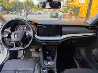 Передняя панель и центральный дисплей Skoda Octavia 2022: широкий экран мультимедиа, руль и элементы управления на консоли.