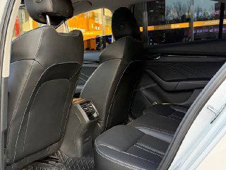 Задний ряд сидений Skoda Octavia 2022, кожаная обивка и пространство для пассажиров, вид с открытой двери.