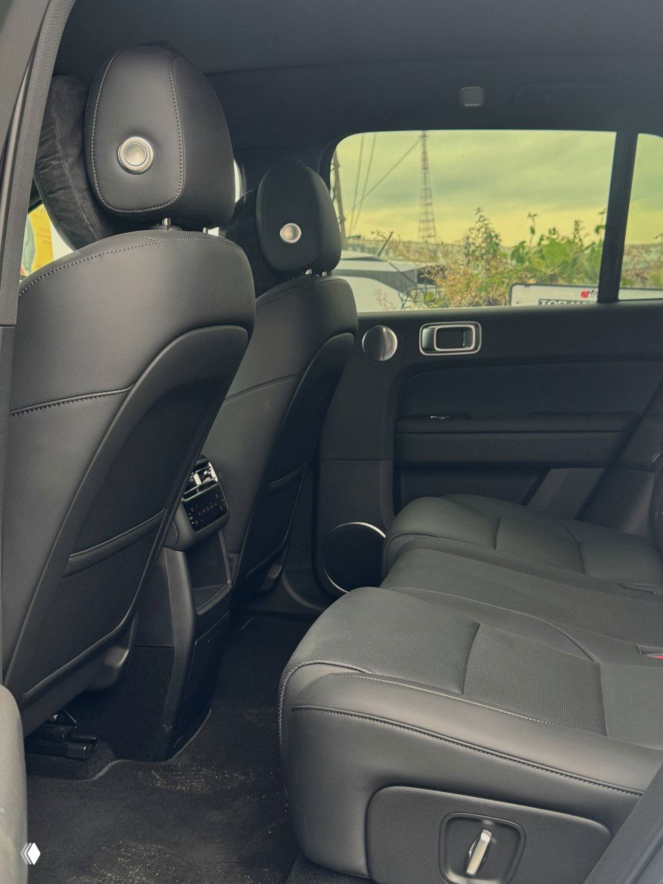 Задние сиденья и пространство салона Lixiang L6 в чёрной отделке, вид на комфортную посадку, подголовники и пространство для ног пассажиров на втором ряду