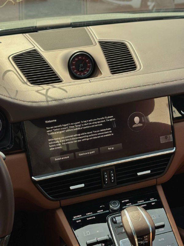 Центральная консоль и цифровой дисплей мультимедиа Porsche Cayenne, видна отделка приборной панели и встроенные воздуховоды и часы на торпедо.