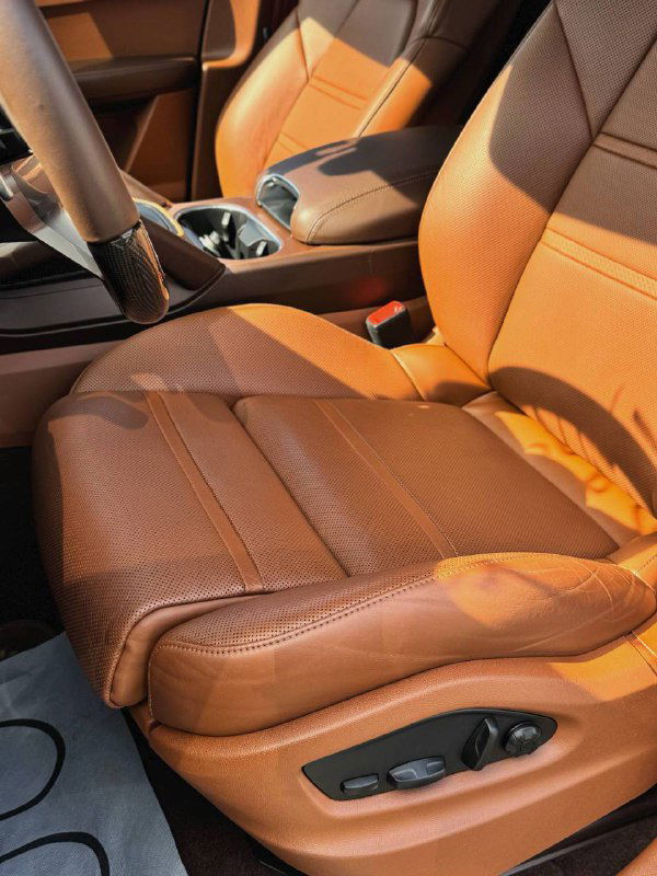 Кожаное сиденье водителя коричневого цвета с перфорацией и электроприводом регулировок, вид боковой части и подушки сиденья в хорошем состоянии.