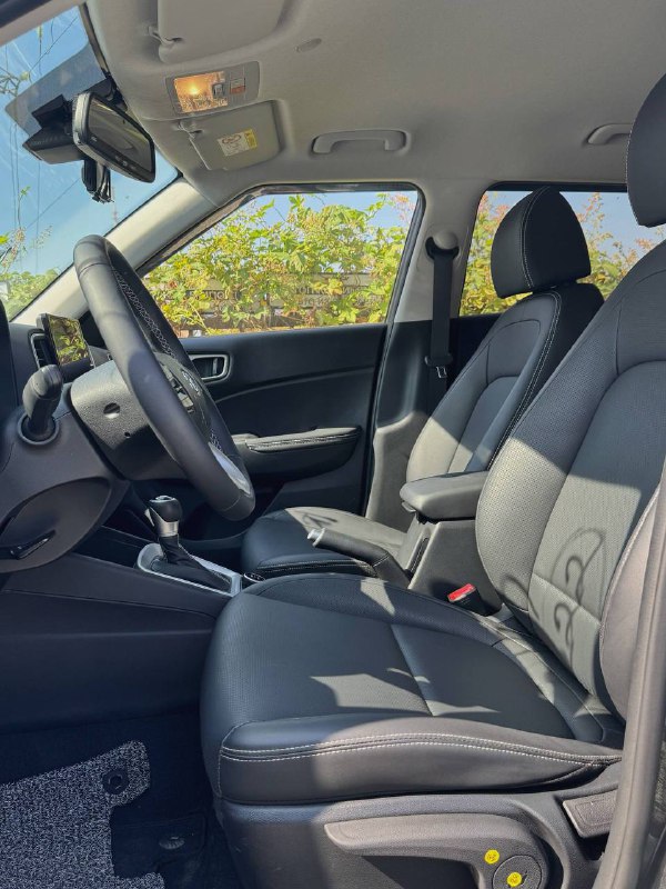 Передние сиденья Hyundai Venue — обивка, регулировки и общее состояние салона со стороны водителя, крупный план интерьера.