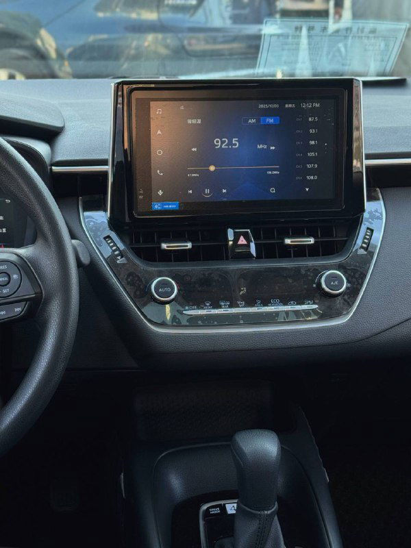 Центральная консоль и мультимедийный экран Toyota Corolla 2022: сенсорный дисплей с воспроизведением радио, элементы управления климатом.