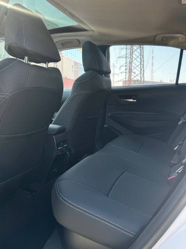 Задний ряд сидений Toyota Corolla 2022: чёрная тканевая обивка, пространство для пассажиров и вид на заднюю часть передних сидений.