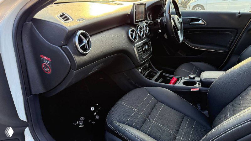 Интерьер Mercedes A‑Class 2013: передние сиденья, центральная консоль и панель, состояние обивки и элементы управления на фото.