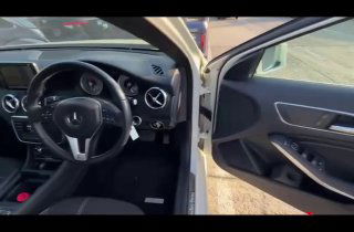 Вид на руль, торпедо и водительскую дверь Mercedes A‑Class 2013 — элементы управления, дверная обшивка и общая компоновка салона на фото.