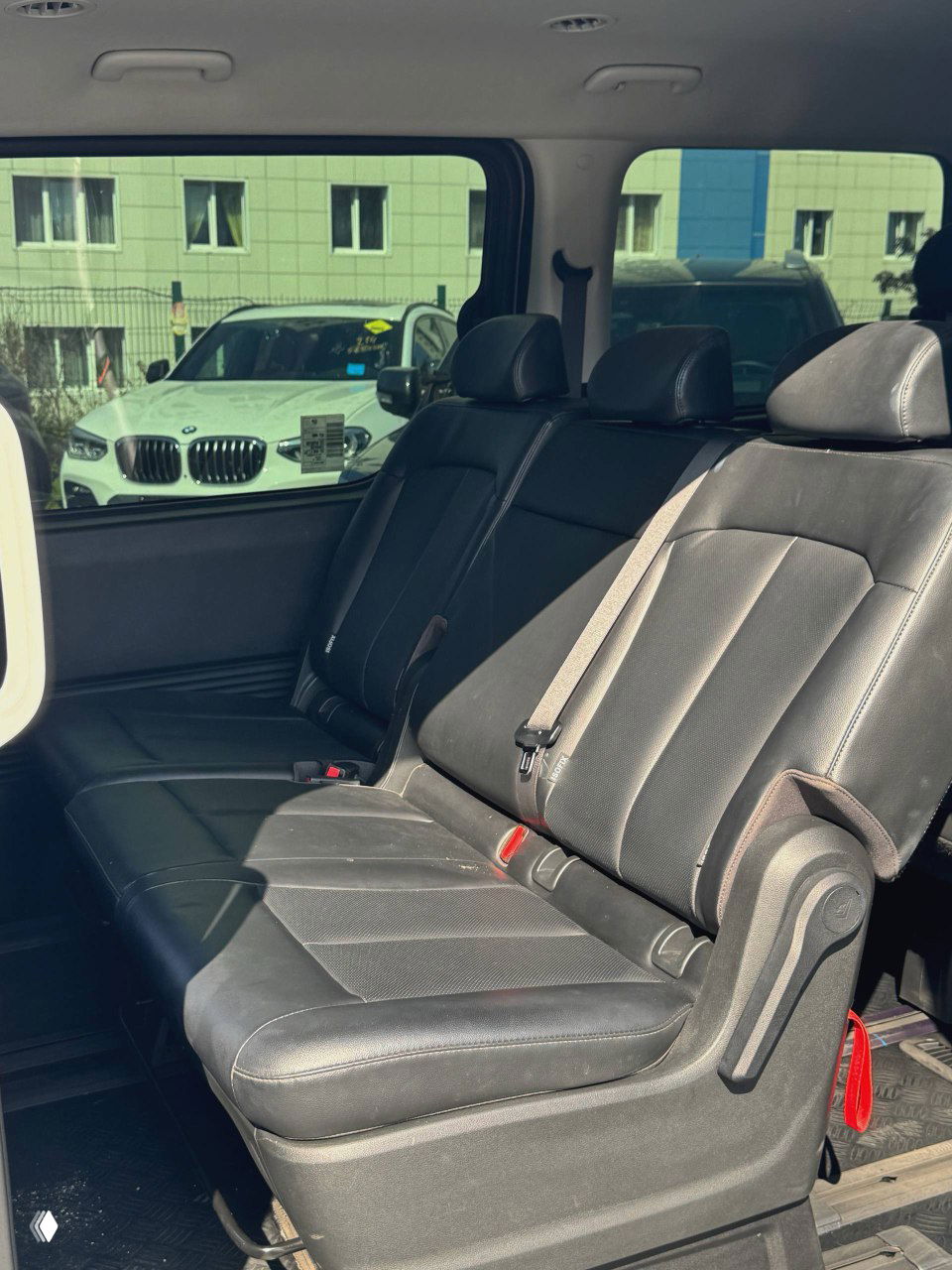 Вид на водительское место и переднюю панель с открытой дверью, видно положение сиденья и общий обзор салона Hyundai Staria