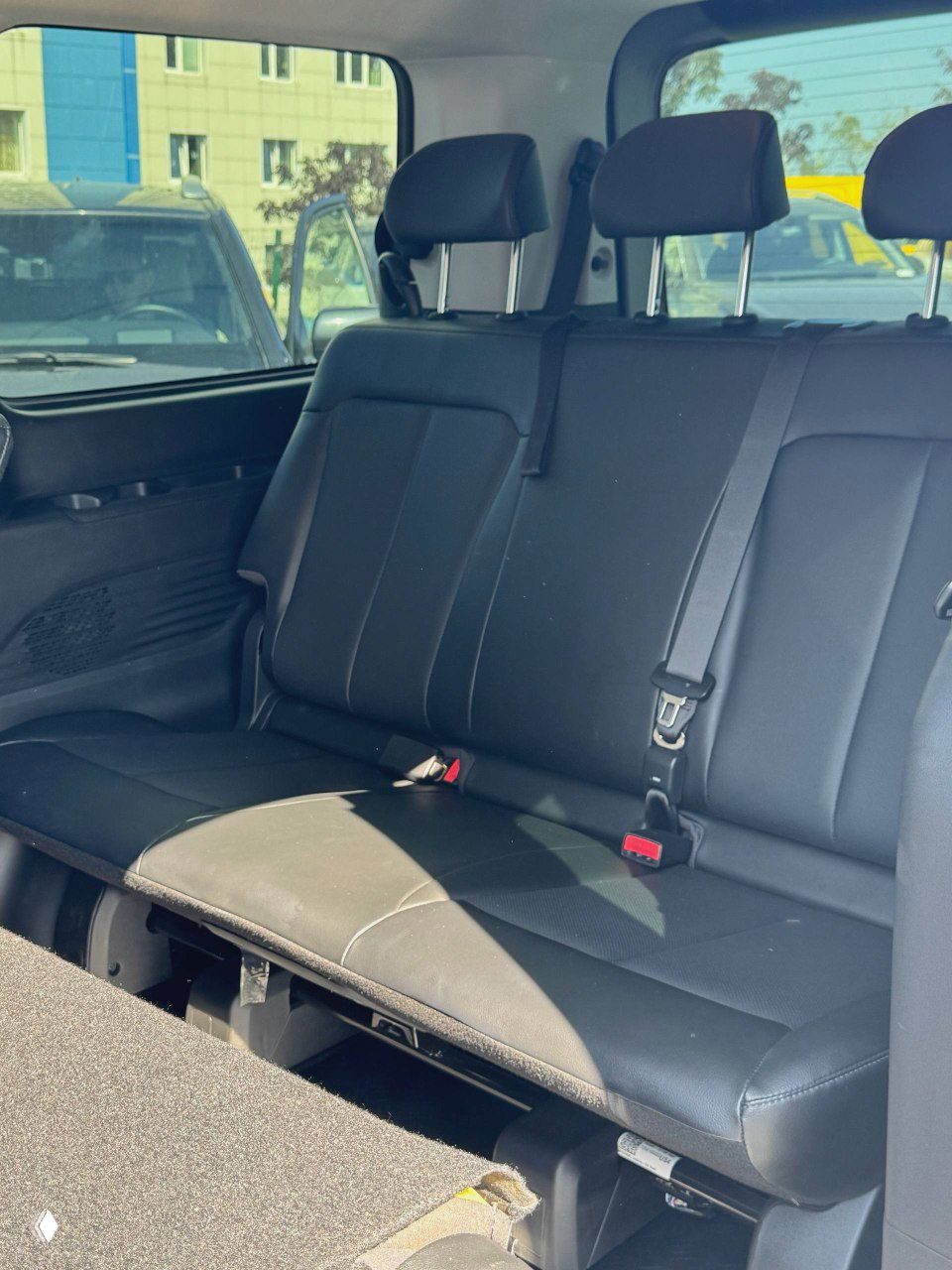 Задние пассажирские сиденья Hyundai Staria в кожаной обивке, вид трёхместного второго ряда и места для багажа, ремни в порядке