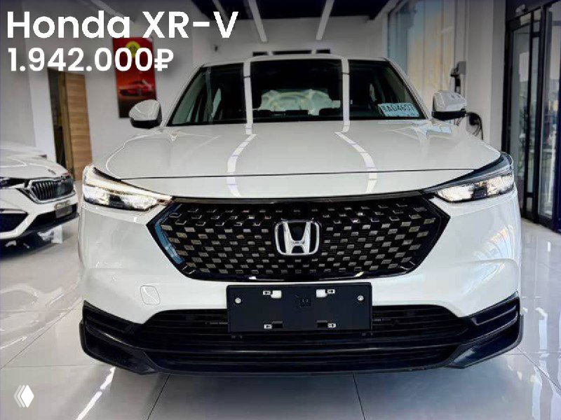 Фронтальное фото белого Honda XR-V в салоне/шоуруме; видна решётка радиатора и часть интерьера, цена указана в левом верхнем углу.