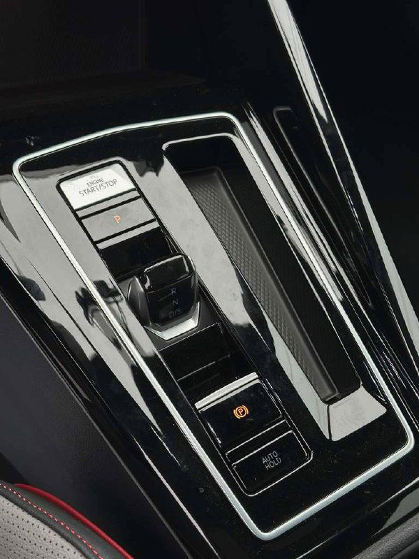 Блок селектора и центральный тоннель Volkswagen Golf GTI, глянцевые поверхности и электронный ручной тормоз на крупном плане.