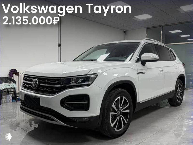 Белый Volkswagen Tayron 2021 года в выставочном зале в Китае, вид спереди; на фото указана цена 2.135.000 ₽ и отметка «Без окрасов».