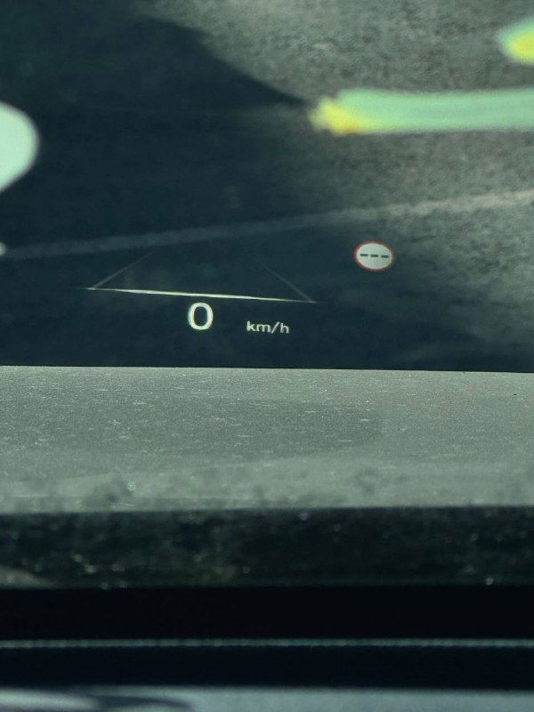 Проекция HUD на лобовом стекле Hyundai Palisade с индикацией скорости 0 км/ч на фоне отражений уличной парковки и пометок на стекле.