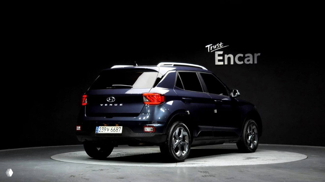 Задний трёхчетвертной вид Hyundai Venue в студии: открытая багажная часть, эмблема VENUE, корейский регистрационный номер и общая геометрия кузова.