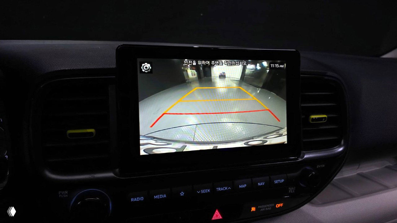 Экран мультимедиа с изображением парковочной камеры Hyundai Venue: разметка для парковки, изображение задней зоны и элементы интерфейса на экране.