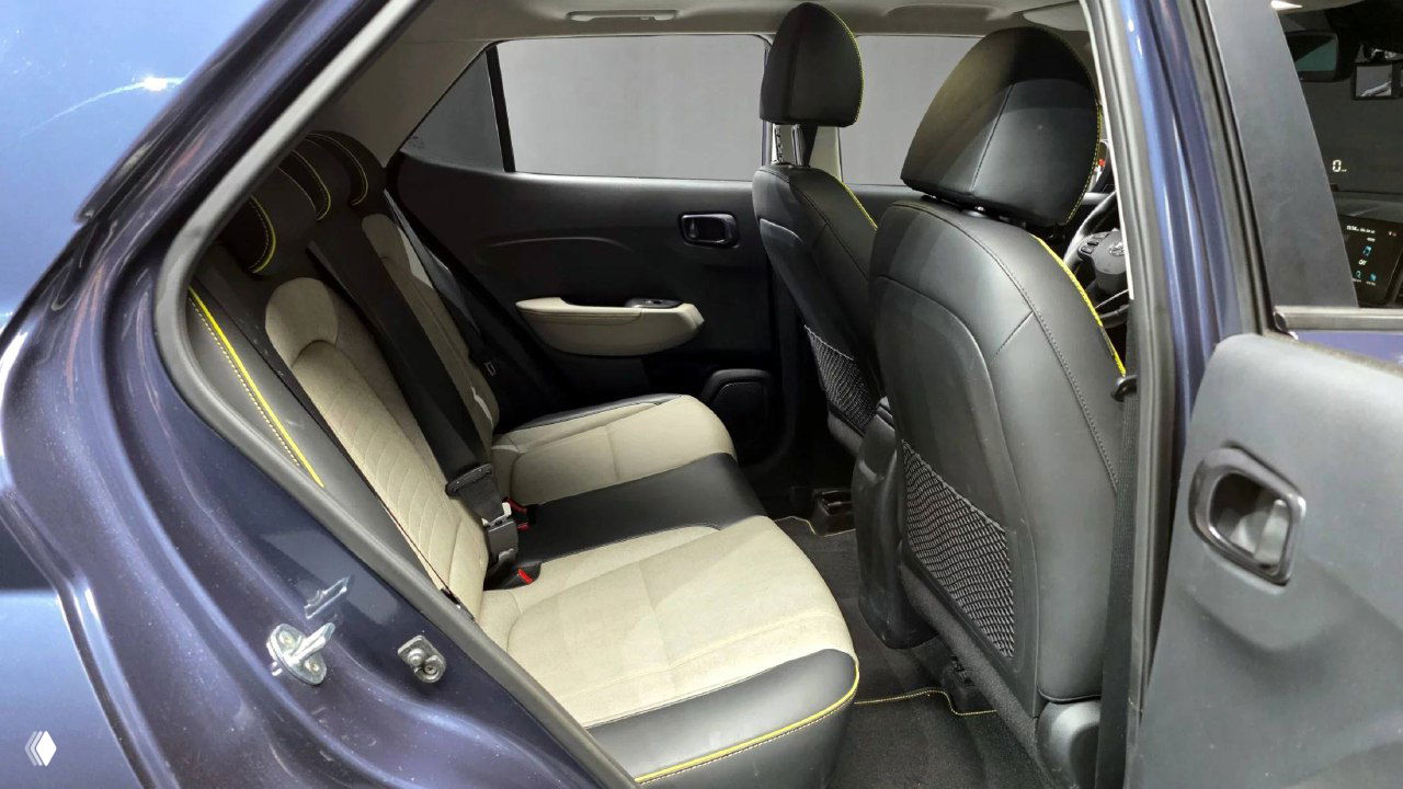 Задний ряд сидений Hyundai Venue: двухцветная тканевая обивка с декоративной жёлтой прострочкой, пространство для ног и общая планировка салона сзади.