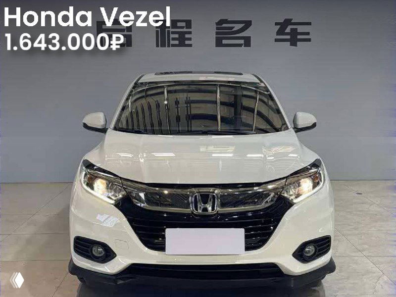 Белая Honda Vezel, фронтальный вид в салоне или выставочном пространстве, на фото видна цена 1.643.000₽ и эмблема Honda на решётке.
