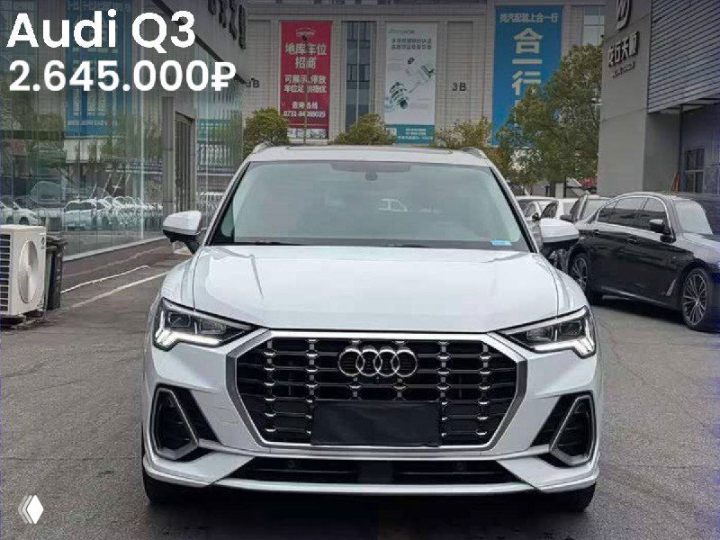 Серебристая Audi Q3, фронтальный вид на городском фоне, авто припарковано у здания, на изображении указана цена 2.645.000₽.