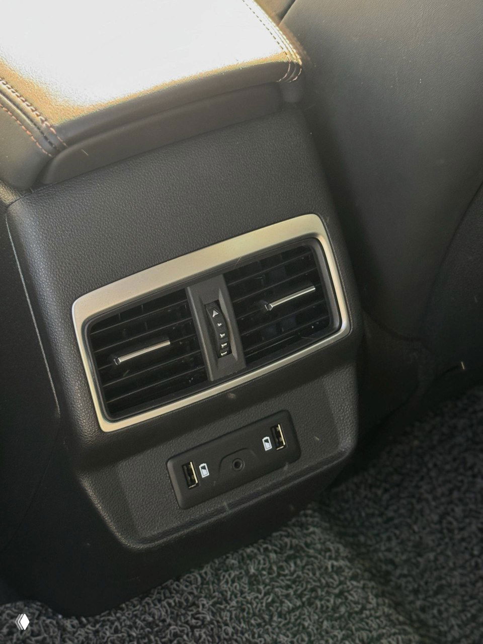 Крупный план задней консоли Samsung QM6 с воздуховодом и двумя USB-портами для зарядки, видна текстура пластика и коврика