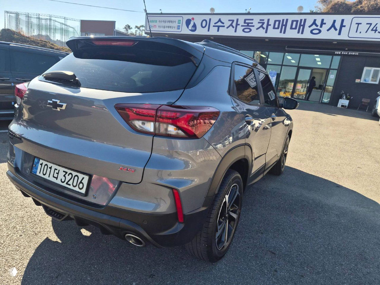 Задняя часть Chevrolet Trailblazer на открытой площадке, показаны фонари, бампер и выхлопная система, видна корейская номерная табличка автомобиля.