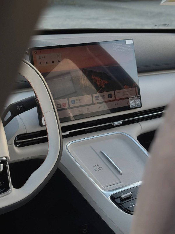 Интерьер Geely Galaxy Starship 7: крупный сенсорный экран мультимедиа на центральной панели, отражения и элементы управления видны со стороны переднего пассажира