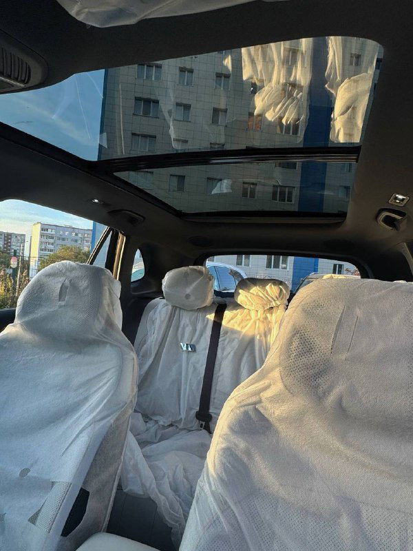 Панорамная крыша Geely Galaxy Starship 7 и общий вид салона сверху, видны упакованные сиденья и свет через стеклянную крышу вечером