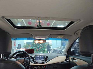 Салон Chevrolet Monza с панорамным люком: вид из задней части на переднюю панель, люк открыт, декоративные элементы интерьера заметны.