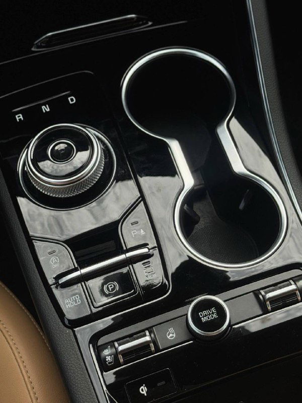 Передняя консоль с селектором передач, подстаканниками и элементами управления — видно блестящую отделку и эргономику центральной зоны.