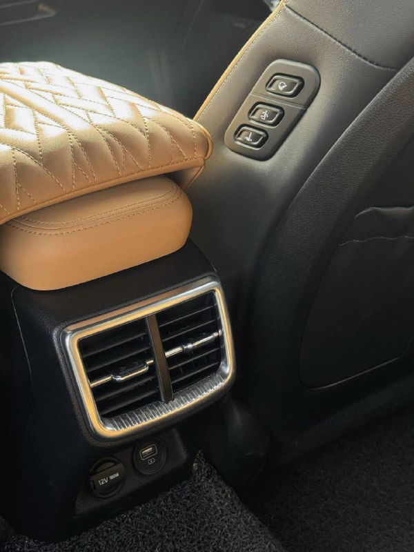 Крупный план вентиляционных решёток задней консоли и панелей управления в салоне — видны USB и разъёмы, обивка и элементы отделки.