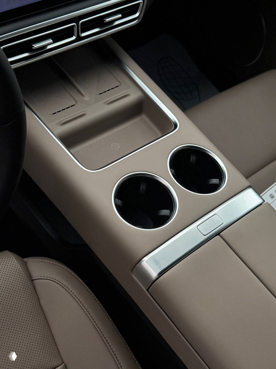 Центральная консоль и подстаканники Lixiang L6 в кофейном оттенке салона, крупный план отделки и мест для хранения, вид на передний блок между сиденьями.