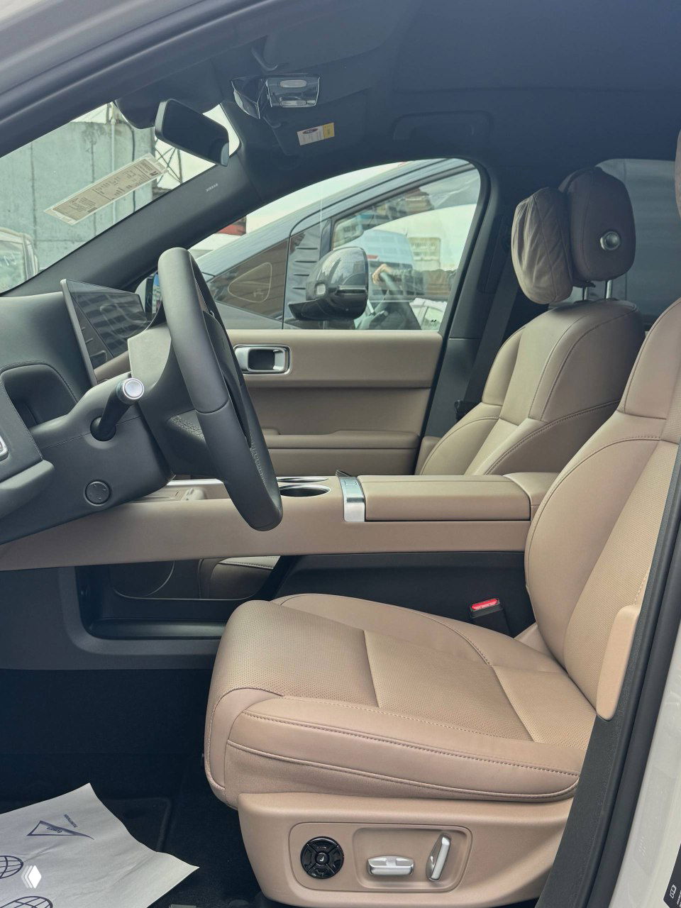 Переднее пассажирское место Lixiang L6, кофейный кожаный салон, электрорегулировки сиденья и интерьерный дизайн с видимыми деталями отделки и подголовниками.