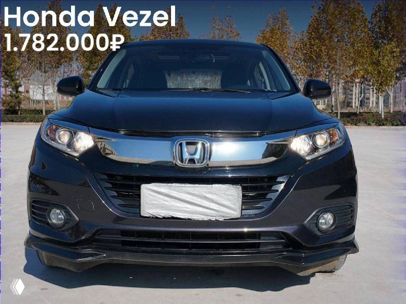 Фронтальный вид тёмно-синего Honda Vezel на открытой площадке с деревьями на заднем плане, цена 1.782.000₽ видна на изображении.
