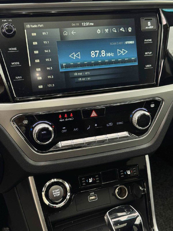 Мультимедийный экран и блок управления климатом в салоне SsangYong Korando, отображена радиочастота 87.8 МГц и элементы управления.