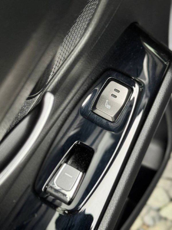 Крупный план кнопок управления стеклоподъёмниками и декоративной отделки двери SsangYong Korando с глянцевыми элементами.