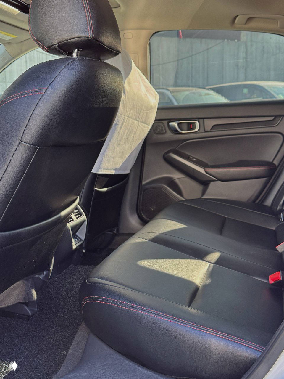 Задний ряд сидений Honda Integra: тёмная обивка с контрастной прострочкой, видно пространство для ног и дверные панели.