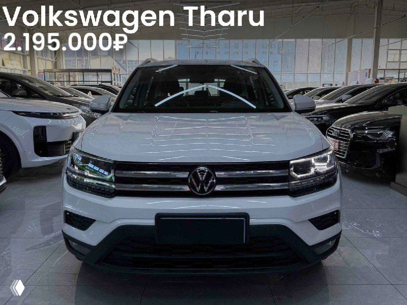 Белый Volkswagen Tharu в автосалоне: фронтальная фотография с чётким видом бампера и фар, автомобиль выставлен для продажи с ценой.