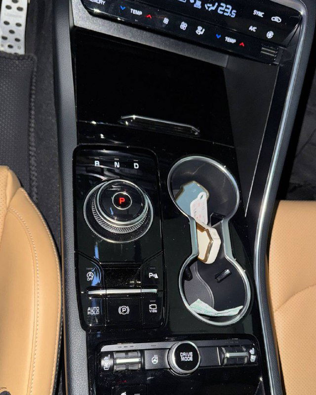 Центральная консоль KIA K5 с шайбой переключения, подстаканником и элементами управления климата вблизи — демонстрация салонных деталей и состояния отделки