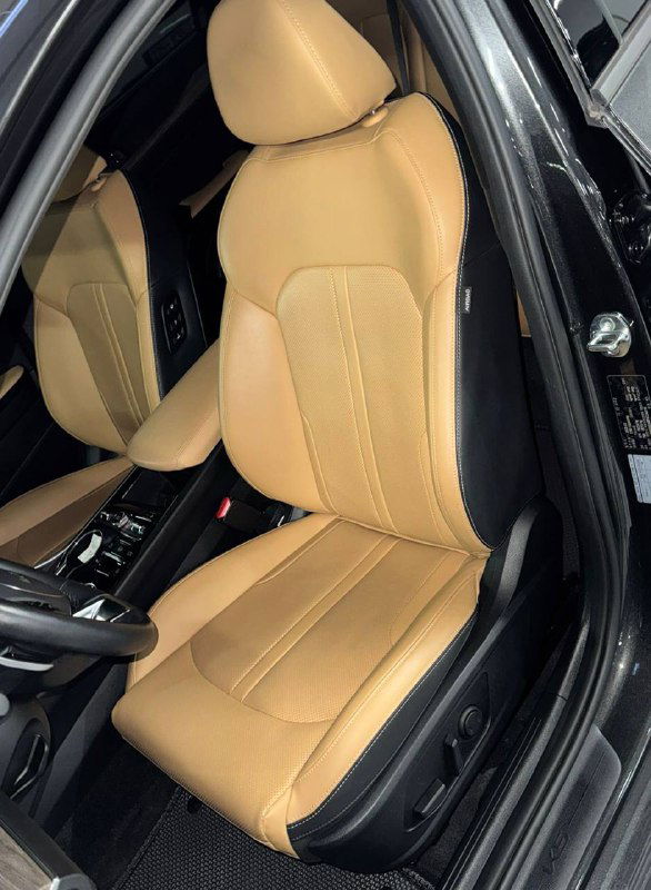 Переднее кресло KIA K5 2023 в коричневой кожаной обивке: вид на сиденье водителя, состояние кожи и боковой профиль среза кресла