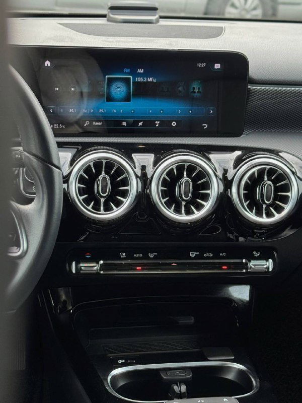 Центральная панель Mercedes A200d: большой мультимедийный экран, три круглых дефлектора вентиляции и часть передней консоли салона.
