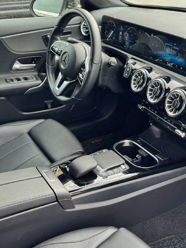 Общий вид передней части салона Mercedes A200d: кресло, руль, панель приборов и центральная консоль в эргономичной компоновке.