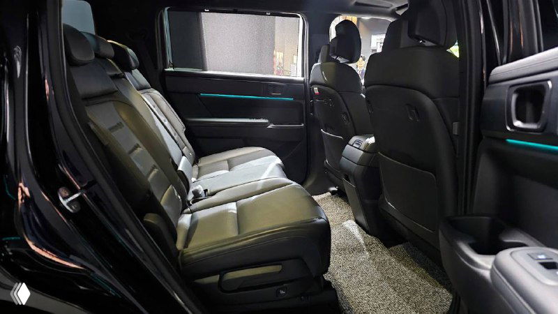 Второй ряд сидений Hyundai Santa Fe Calligraphy: кожаная обивка, пространство для ног и вид на переднюю часть салона с подсветкой.