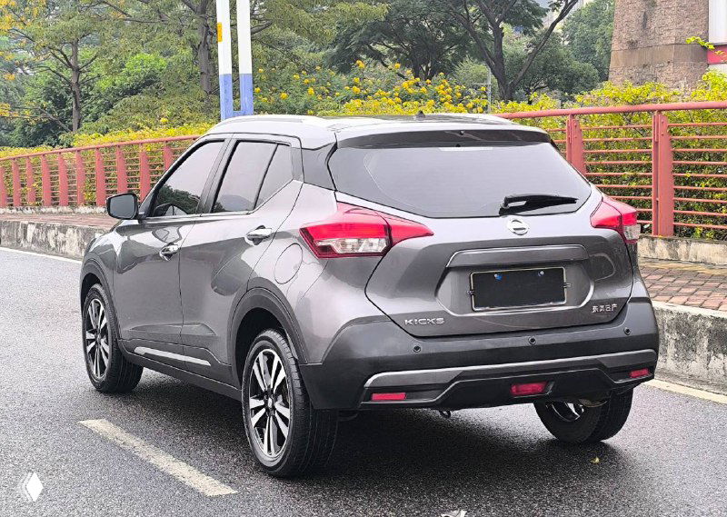 Задний ракурс серого Nissan Kicks 2021 — вид сзади, багажник и задние фонари на стоянке в городской среде.