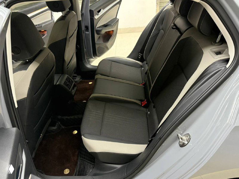 Задние сиденья Volkswagen Golf 2021: пространство для пассажиров, трёхместная лавка, ремни безопасности и чистая тканевая обивка на светлом фоне салона.