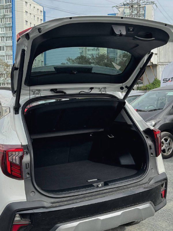 Открытый багажник KIA Seltos — вид вместительного грузового отсека с ровным полом багажника и отделкой внутренних стенок.