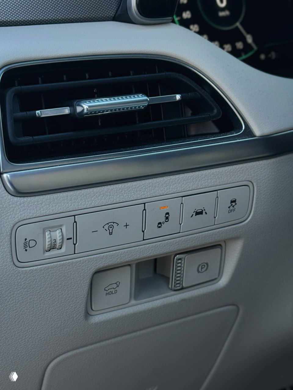 Кнопки и органы управления на торпедо Hyundai Palisade: включение парковочного тормоза, ассистенты движения и регулировки освещения.