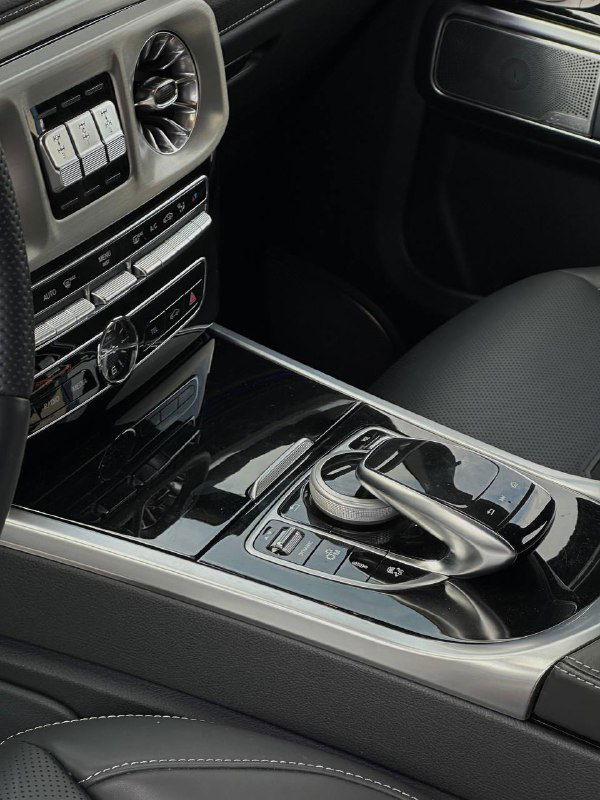 Центральная консоль Mercedes G63 AMG — кнoпки мультимедиа, селектор коробки и глянцевая отделка между передними сиденьями.