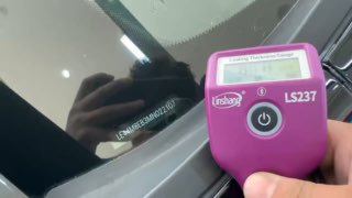 Фото номера кузова или крупный кадр лобового стекла с идентификационными надписями — показывает детали VIN и маркировки на стекле автомобиля.