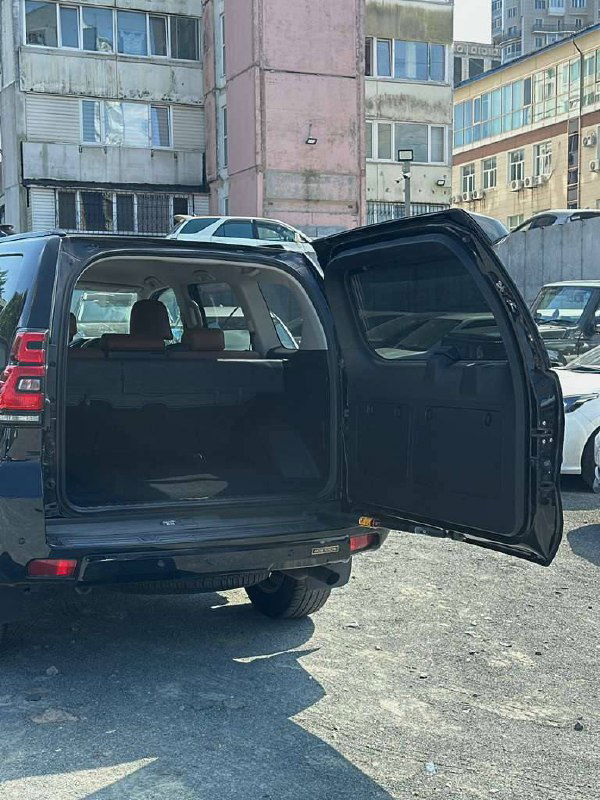 Открытая задняя дверь и багажное отделение Toyota Prado — вид сзади, демонстрирующий грузовой отсек и общий доступ к багажнику.